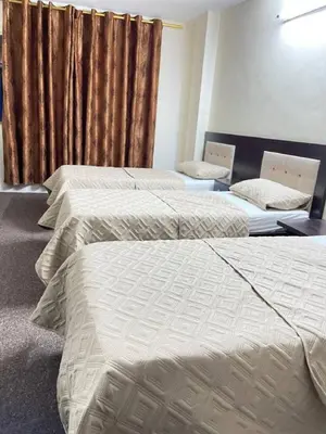 two beds in a hotel room with a curtain at Asia Hotel in Amman
