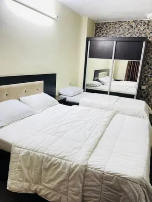 a bedroom with two beds and a large mirror at Asia Hotel in Amman