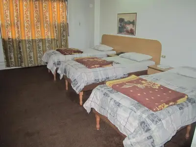 a group of four beds in a room at Asia Hotel in Amman
