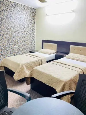 a room with two beds and chairs in it at Asia Hotel in Amman