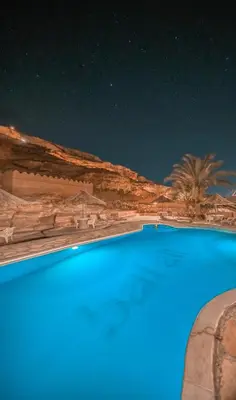 a swimming pool at night in the desert at Bait Ali in Wadi Rum