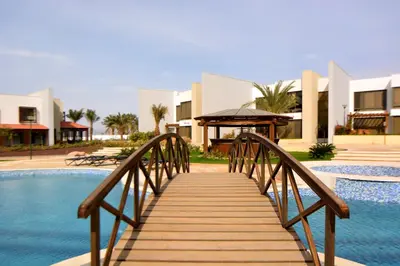 a wooden bridge over a pool in front of a building at Public Security Hotel & Chalets in Aqaba