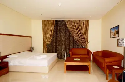 a hotel room with a bed and a chair at Public Security Hotel & Chalets in Aqaba