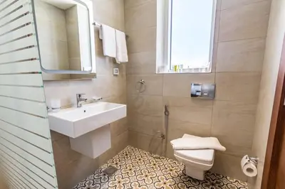 a bathroom with a sink and a toilet and a mirror at The Seventh Star Hotel Suites in Amman
