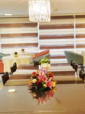 a dining room with a table with flowers on it at The Seventh Star Hotel Suites in Amman
