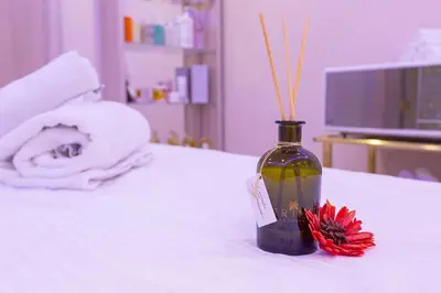 a bottle of wine and a red flower on a bed at Amman International Hotel in Amman