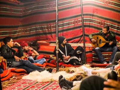 a group of people sitting in a room playing music at Seven Wonders Bedouin Camp in Wadi Musa