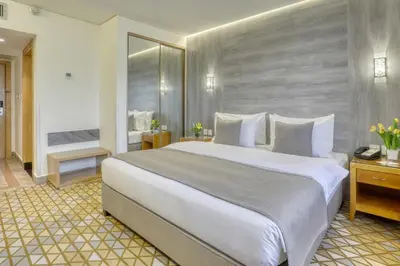 a hotel room with a large bed and a bathroom at Geneva Hotel in Amman