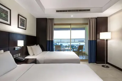 a hotel room with two beds and a balcony at DoubleTree by Hilton Hotel Aqaba in Aqaba