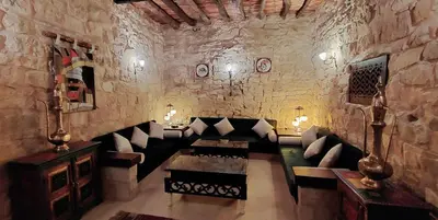 a living room with a couch in a stone wall at Hayat Zaman Hotel And Resort Petra in Wadi Musa