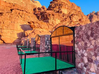 a room in a desert with a rock wall at Wadi Rum Shooting Stars Camp in Wadi Rum
