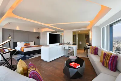 a hotel room with a king sized bed and a living room at W Amman Hotel in Amman