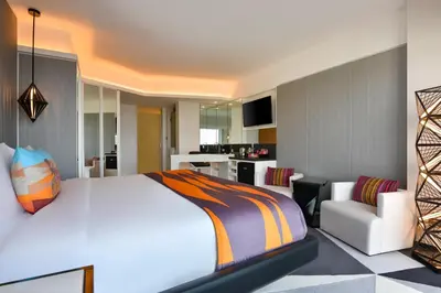 a bedroom with a large white bed and a couch at W Amman Hotel in Amman