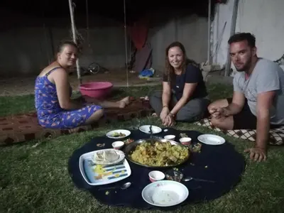 a group of people sitting around a table with food at Climbers House in Wadi Rum in Wadi Rum