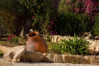 a large vase sitting on the ground next to some rocks at The Old Village Hotel & Resort in Wadi Musa