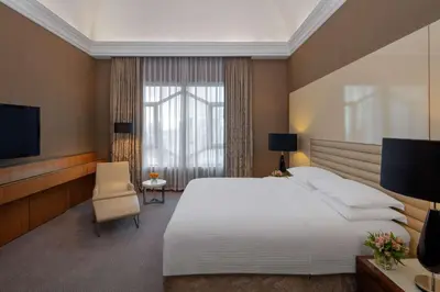 a hotel room with a large bed and a television at Grand Hyatt Amman in Amman