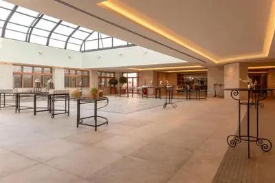 a large lobby with tables and a glass ceiling at Grand Hyatt Amman in Amman