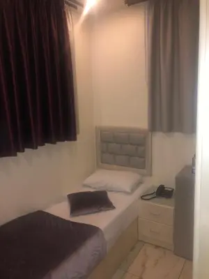 a small bedroom with two beds and a window at Beirut Hotel 1 in Amman
