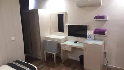 a room with a desk with a computer and a tv at Beirut Hotel 1 in Amman