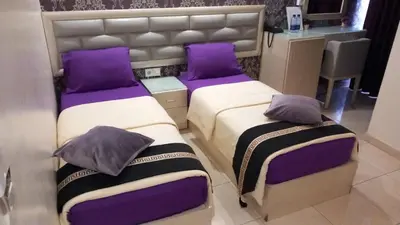 two beds with purple pillows in a room at Beirut Hotel 1 in Amman