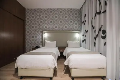a room with three beds and a wall at La Locanda Boutique Hotel in Amman
