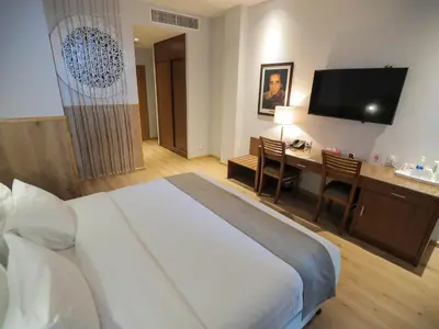 a hotel room with a bed and a desk and a television at La Locanda Boutique Hotel in Amman