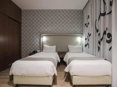 a row of beds in a room with a wall at La Locanda Boutique Hotel in Amman