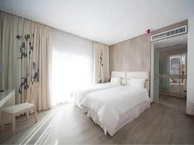 a bedroom with a white bed and a large window at La Locanda Boutique Hotel in Amman