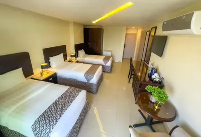 a hotel room with two beds and a table at Dweik Hotel 2 in Aqaba