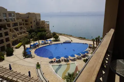 a view of a swimming pool with umbrellas and chairs at Apartment Samarah Resort Sea & Pool view D in Sowayma