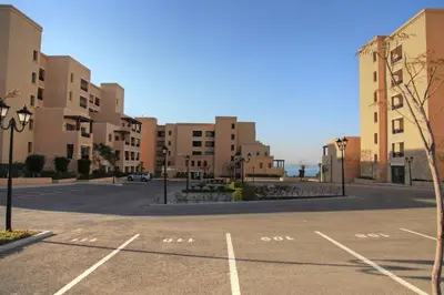 an empty parking lot in a city with buildings at Apartment Samarah Resort Sea & Pool view D in Sowayma