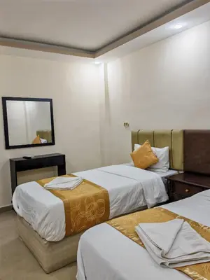 a hotel room with two beds and a mirror at Petra Gate Hotel in Wadi Musa