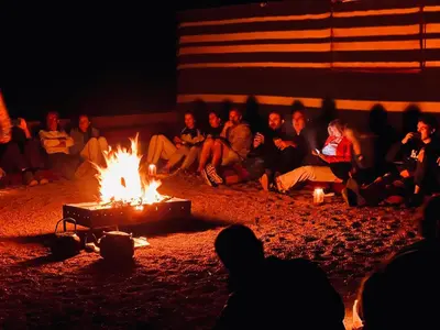 a group of people sitting around a fire at Bedouin Lifestyle Camp in Wadi Rum