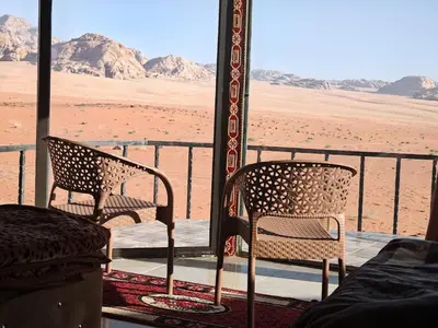 two chairs sitting on a porch in the desert at Bedouin Lifestyle Camp in Wadi Rum