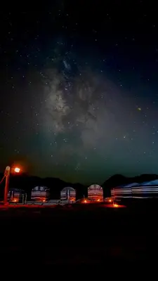 a group of buildings under a starry sky at night at Bedouin Nights Camp in Wadi Rum