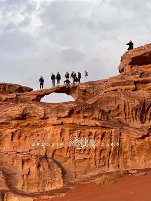a group of people standing on top of a cliff at Bedouin Nights Camp in Wadi Rum