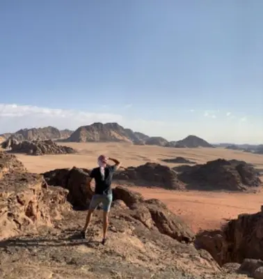 a man standing on the rocks in the desert at Joy to Wadi Rum in Wadi Rum