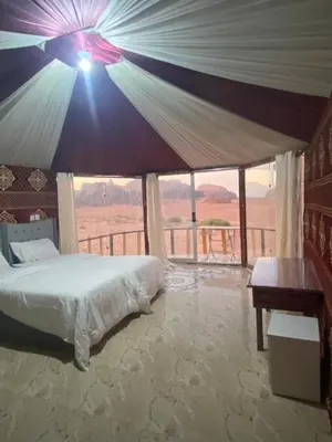 a bedroom with a bed and a view of the desert at Joy to Wadi Rum in Wadi Rum