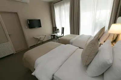 a hotel room with three beds and a television at The Conroy Boutique Hotel in Amman