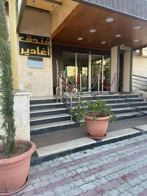 a lobby of a building with potted plants in front at Aghadeer Hotel in Amman