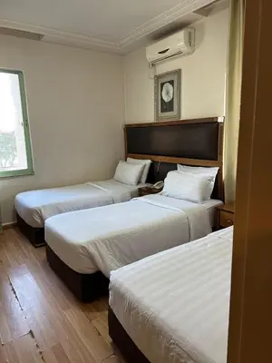 a hotel room with two beds and a window at Aghadeer Hotel in Amman