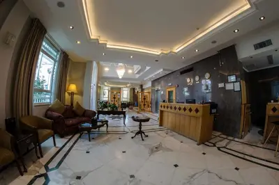 a living room with a couch and a table at Kindi Suite Hotel in Amman