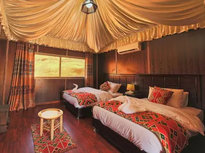 a bedroom with two beds and a canopy at Mazayen Rum Camp in Wadi Rum