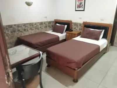 a hotel room with two beds and a table at Amman Palace Hotel in Amman