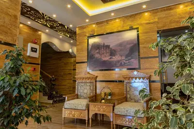 a room with two chairs and a table and a painting at Town Season Hotel in Wadi Musa