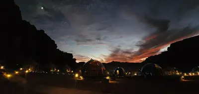 a group of domed buildings with lights at night at Memories Aicha Luxury Camp in Wadi Rum