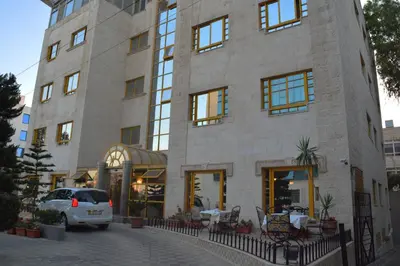 a building with a car parked in front of it at Capri Hotel Suites in Amman