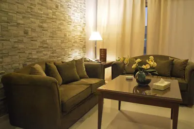 a living room with two couches and a coffee table at Capri Hotel Suites in Amman