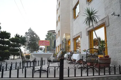 a restaurant with tables and chairs outside of a building at Capri Hotel Suites in Amman