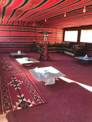 a red room with two tables and a couch at Bedouin House Camp in Wadi Rum